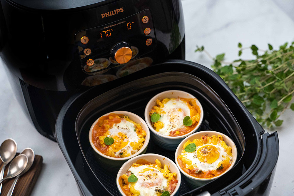Four Mac and cheese and half baked egg ramekins cooked in a Philips Premium Airfryer