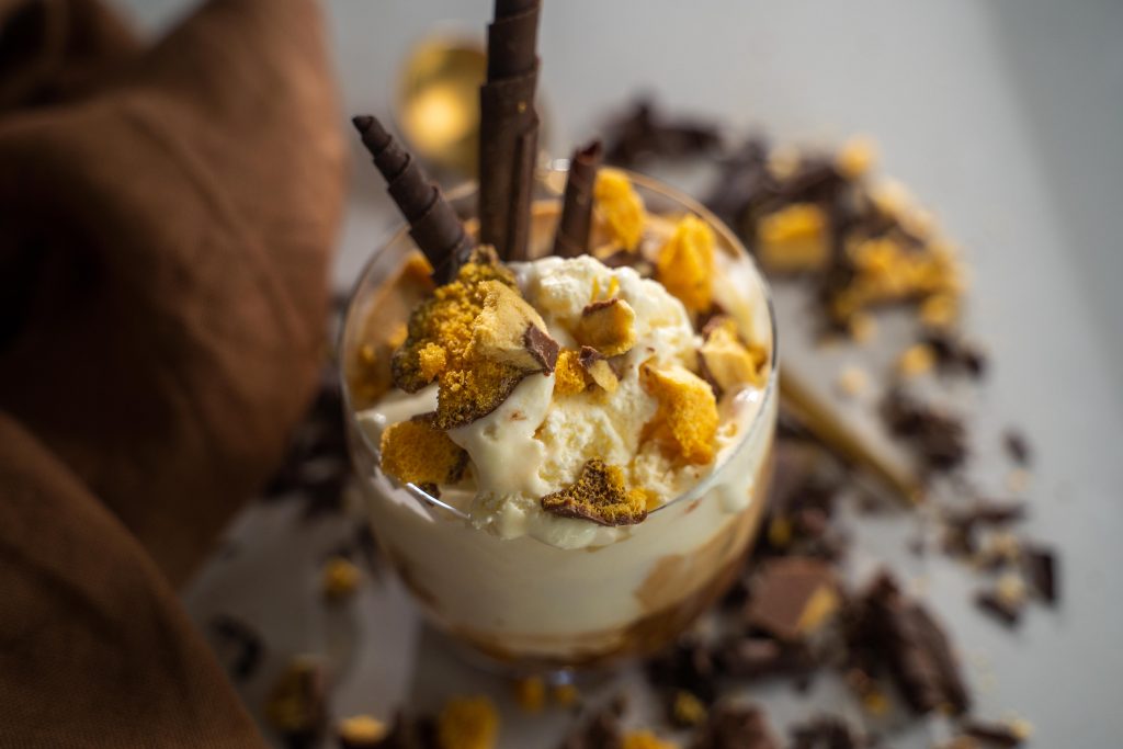 Hokey pokey affogato in a glass with honeycomb pieces and chocolate curls